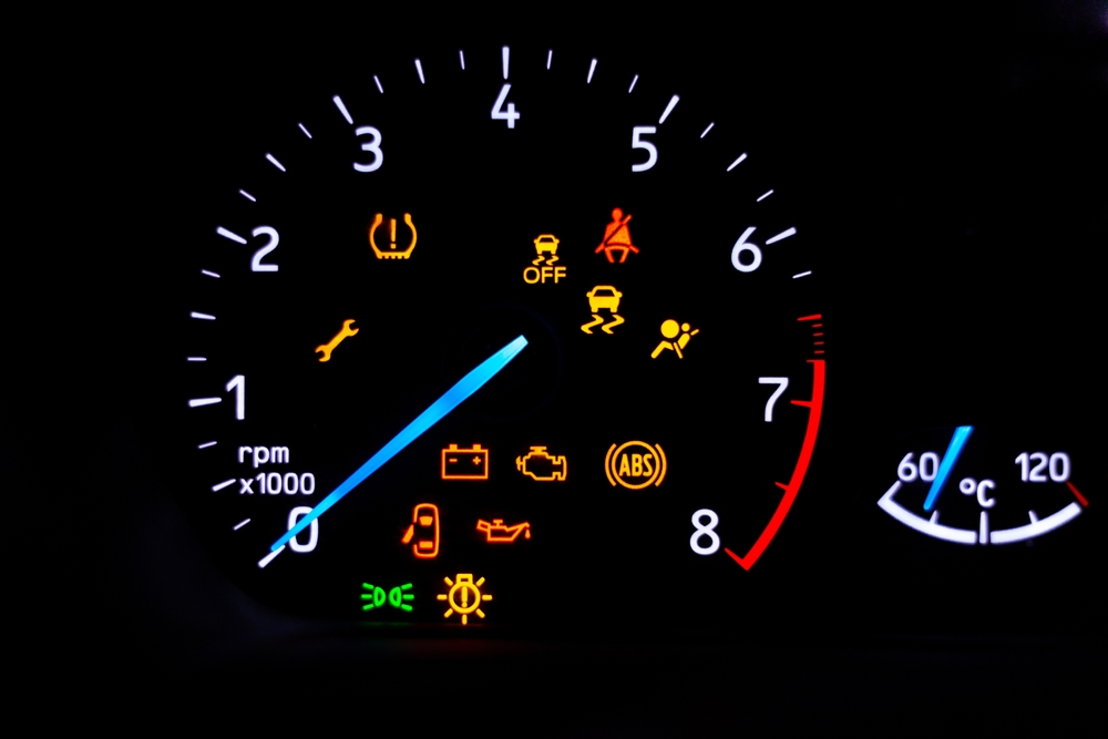 A car's dashboard lights up with multiple alert icons, signaling various vehicle functions and warnings in a clear, colorful display.